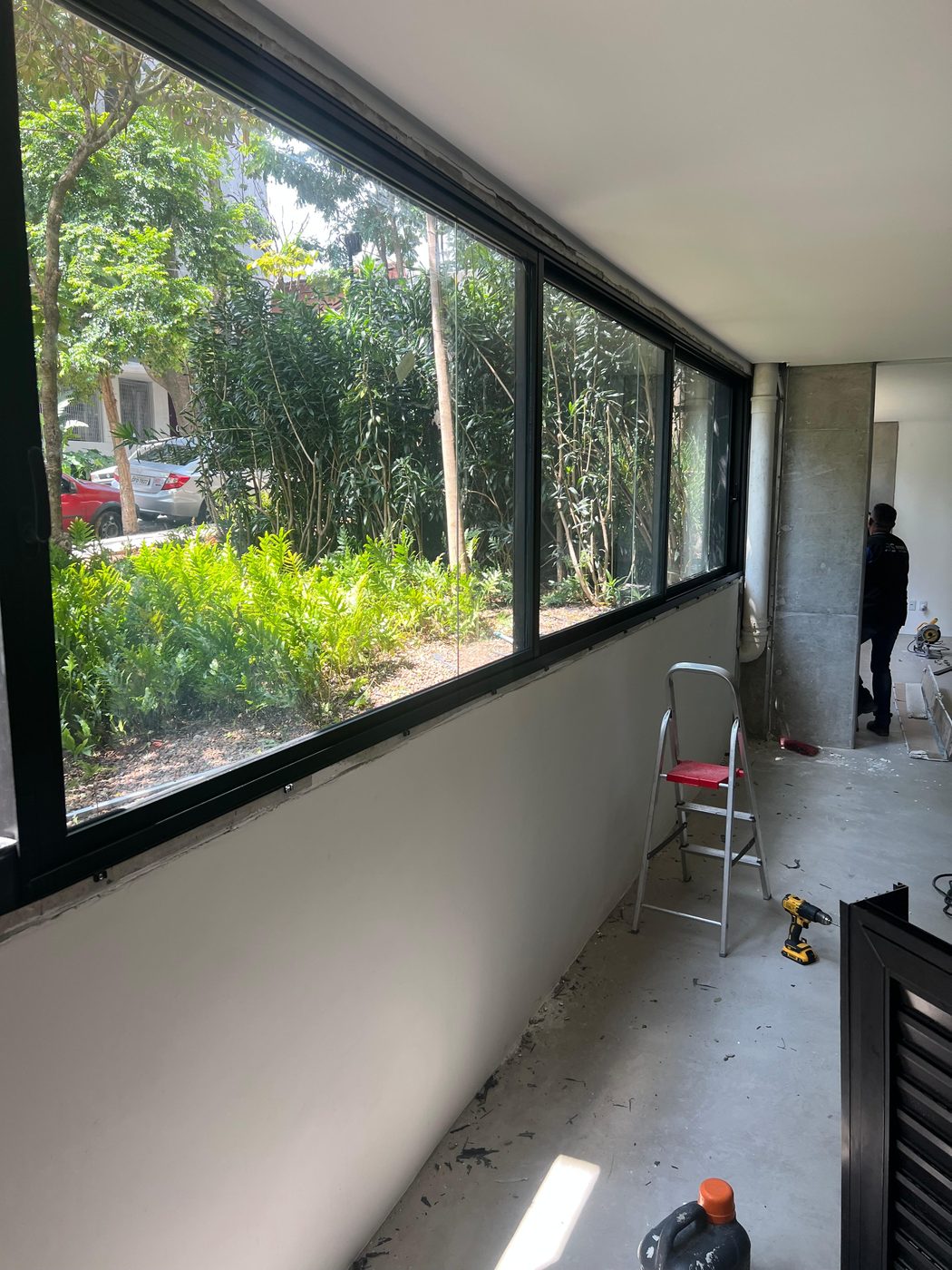 Janela panorâmica de alumínio instalada em sala, com vista para o jardim
