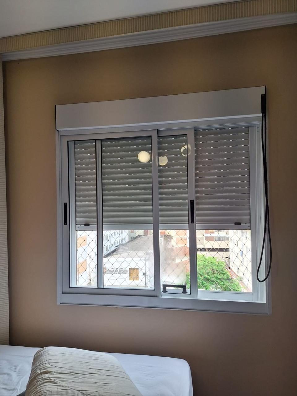 Janela de quarto com veneziana após manutenção